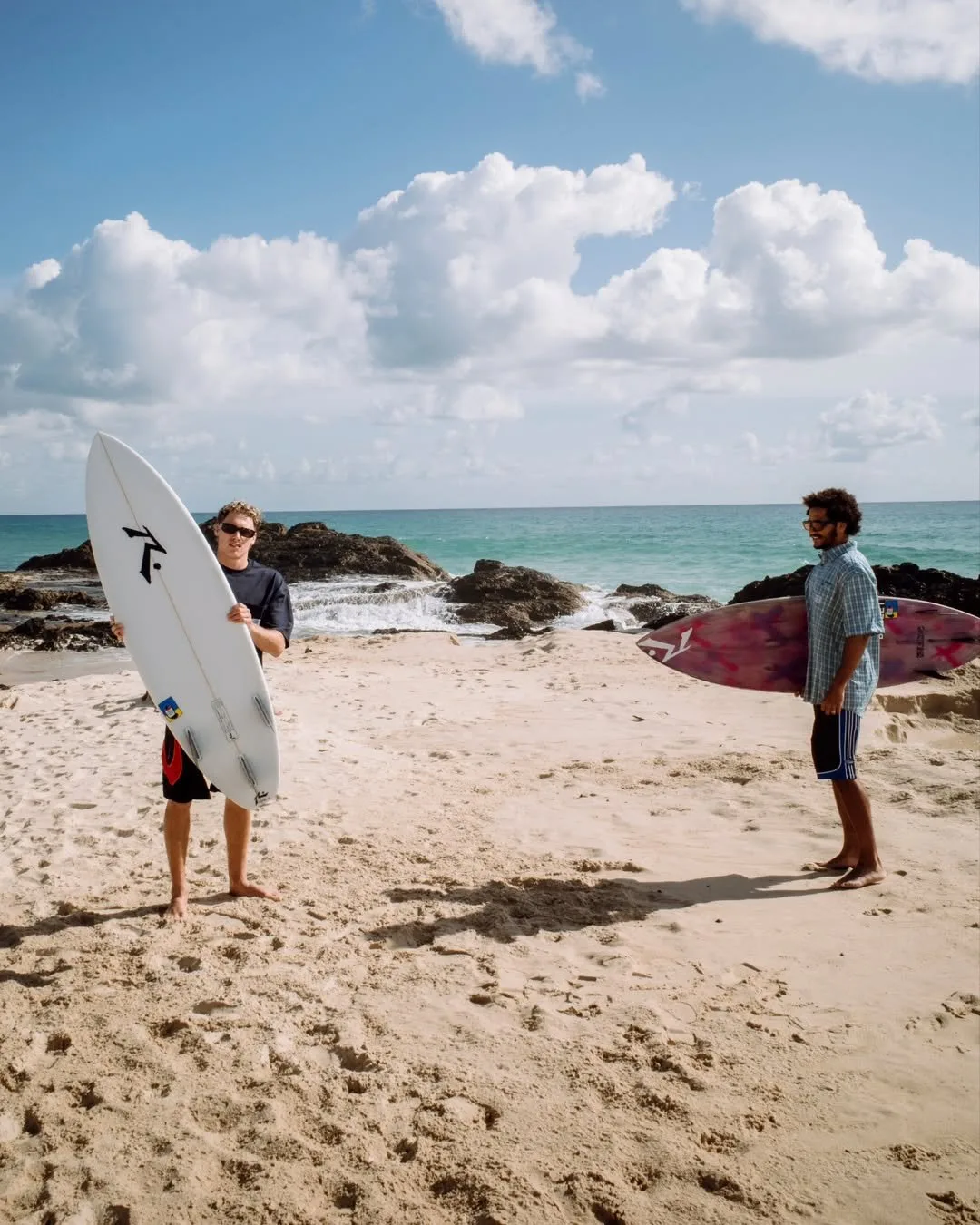 Dos surfistas en la playa con anteojos de sol